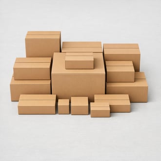 Flat lay of neatly stacked corrugated cardboard boxes in various sizes on a clean warehouse floor
