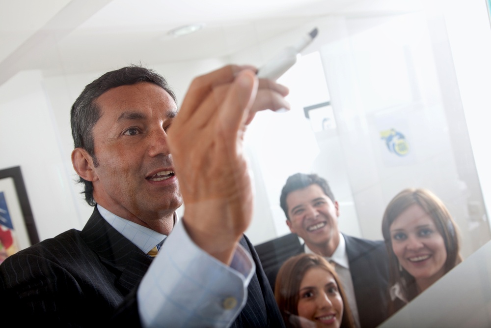 Man drawing a business plan and showing it to a group